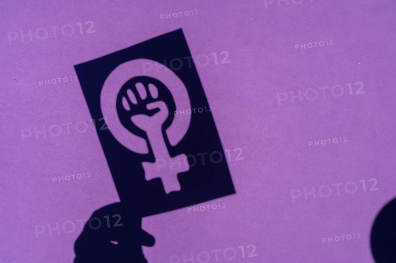 Shadow of the symbol of the fight for feminism on a purple background