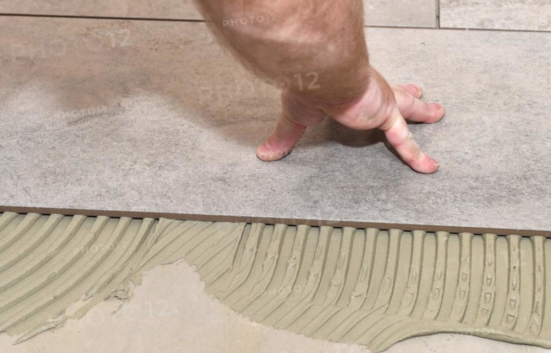 Tiler lays tiles on the floor