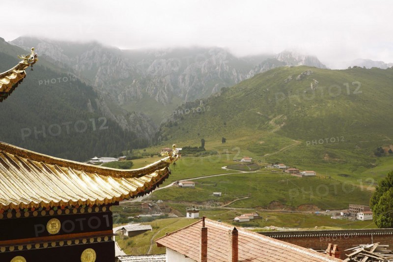Golden temple roofs and green valleys in the mountain landscape