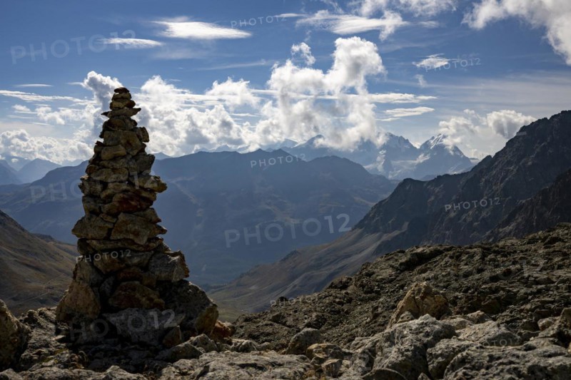 Cairn with Engadine Mountains and Cloudy Sky