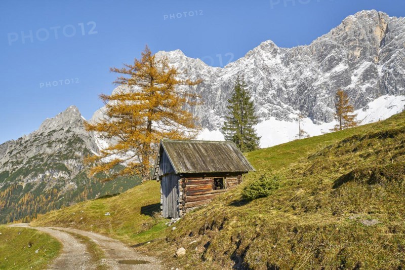 Hay barn in front of mountain scenery in autumn