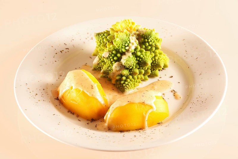 A portion of romanesco with boiled potatoes and cheese sauce