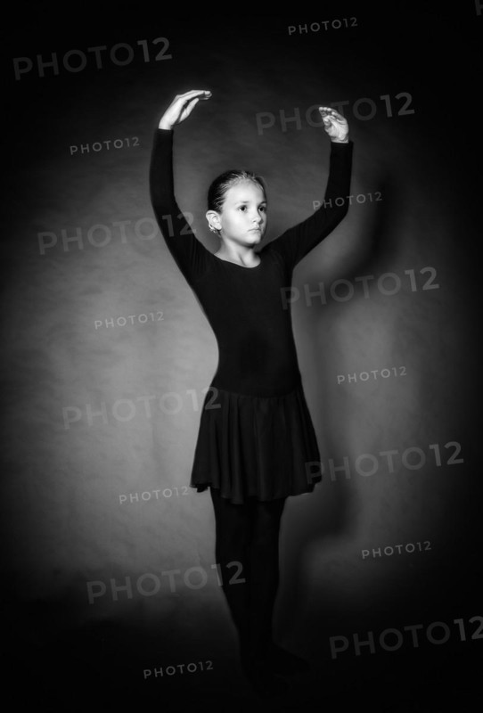 Young girl in dancewear stands in position