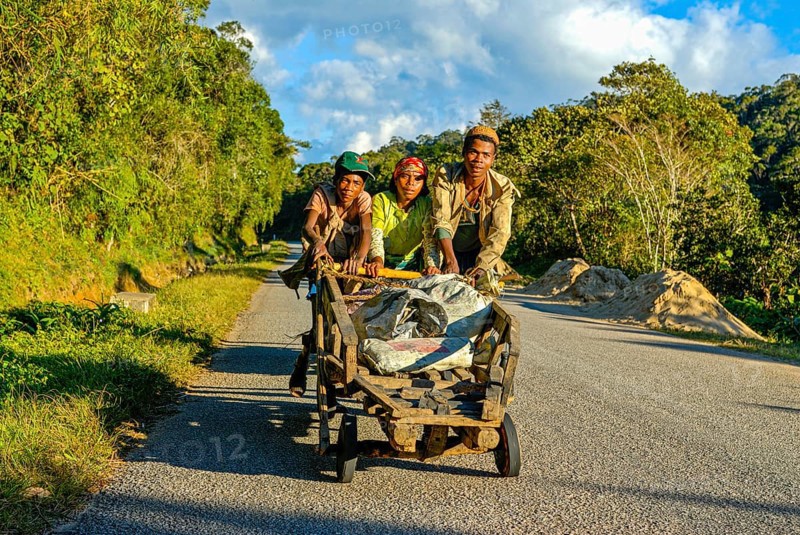 Young boys pushing self made carts up the hill