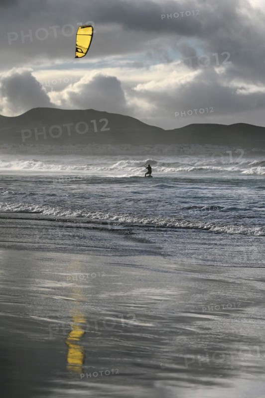 Kitesurfers at sunset on the beach of Caleta de Famara
