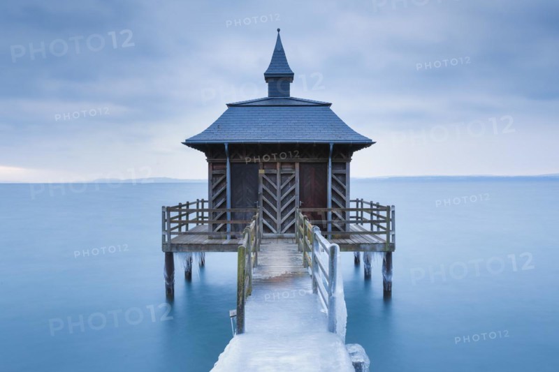 Iced wooden bathhouse at dawn on Lake Neuchatel in Gorgier