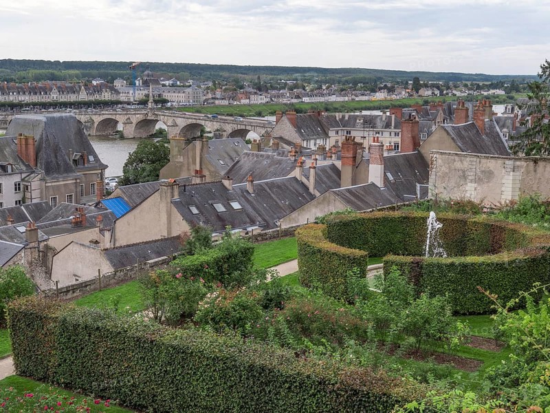 View of Roseraie des jardins de leveche and in the background the city of Blois and the Jacques Gabriel Bridge