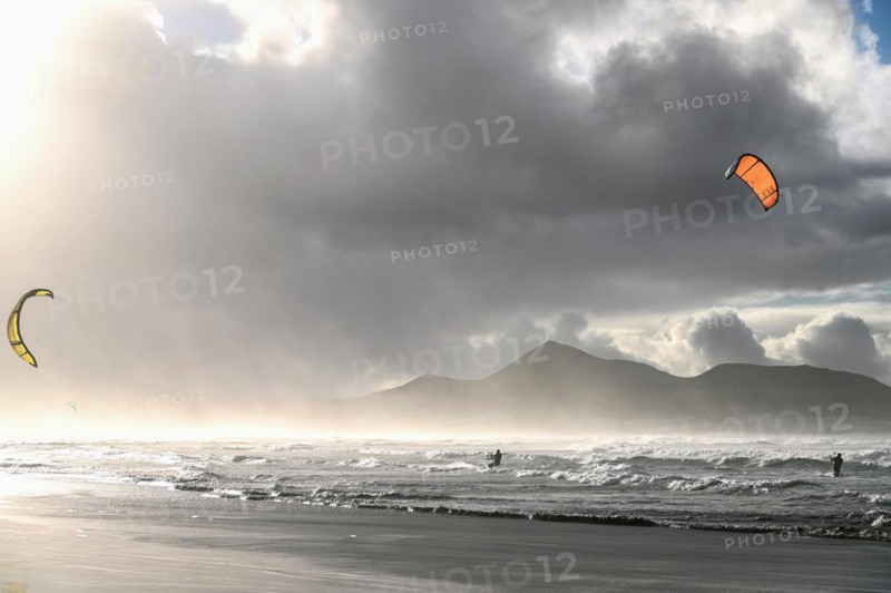 Kitesurfers at sunset on the beach of Caleta de Famara
