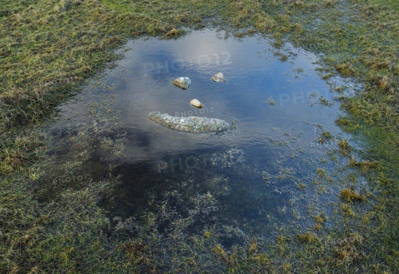 A natural smiley made of stones in the middle of a puddle of water in the Highlands of Scotland