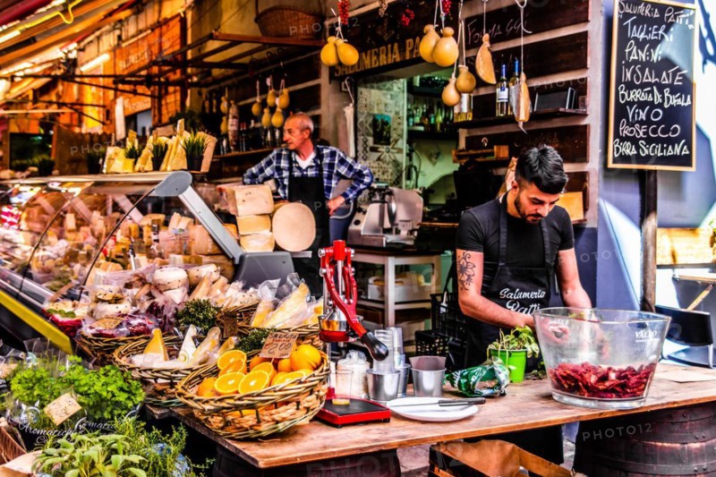 Ham and cheese stall at the historic fish market La pescheria with an abundance of colourful seafood