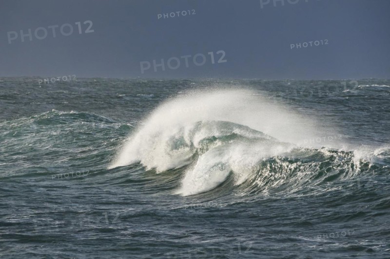 Big wave breaks in the open sea on the Breton coast near Brest