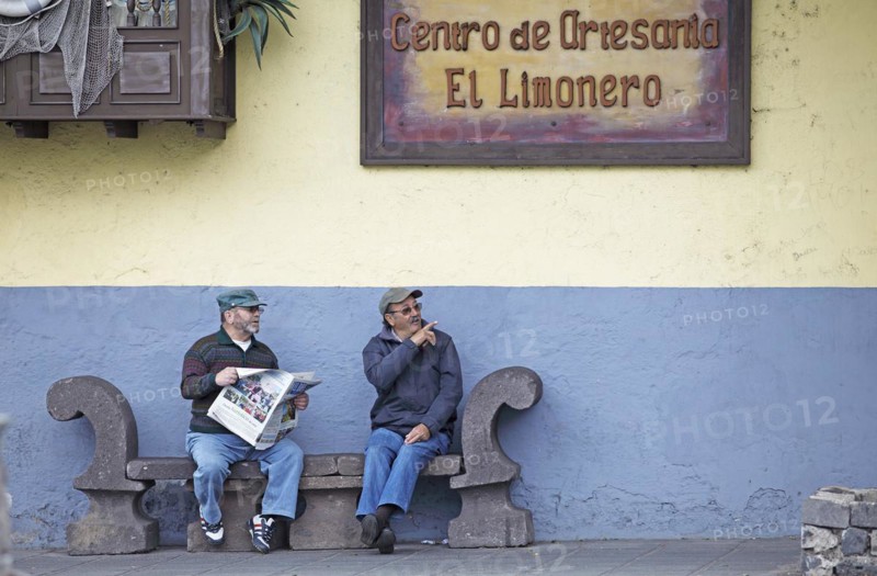 Old men reading newspaper on a bench