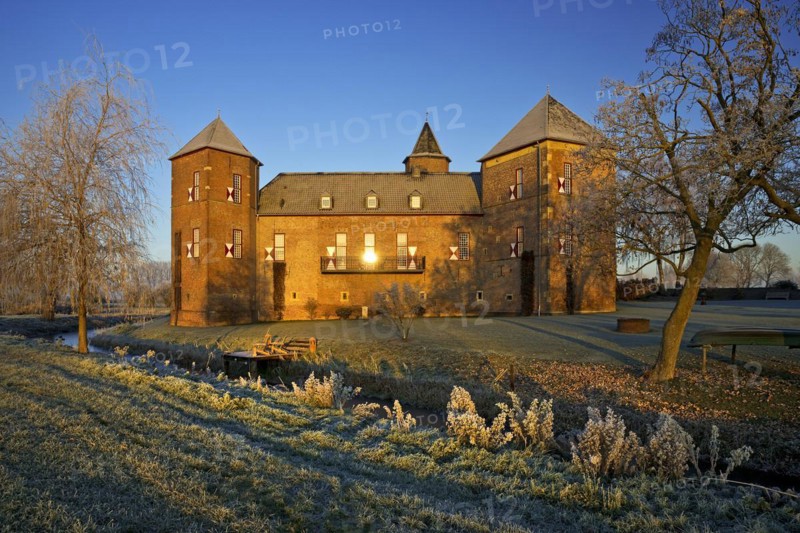 Water castle Haus Zelem with hoarfrost at sunrise