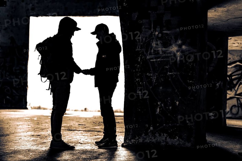 Two men as silhouette in bunker with graffiti walls