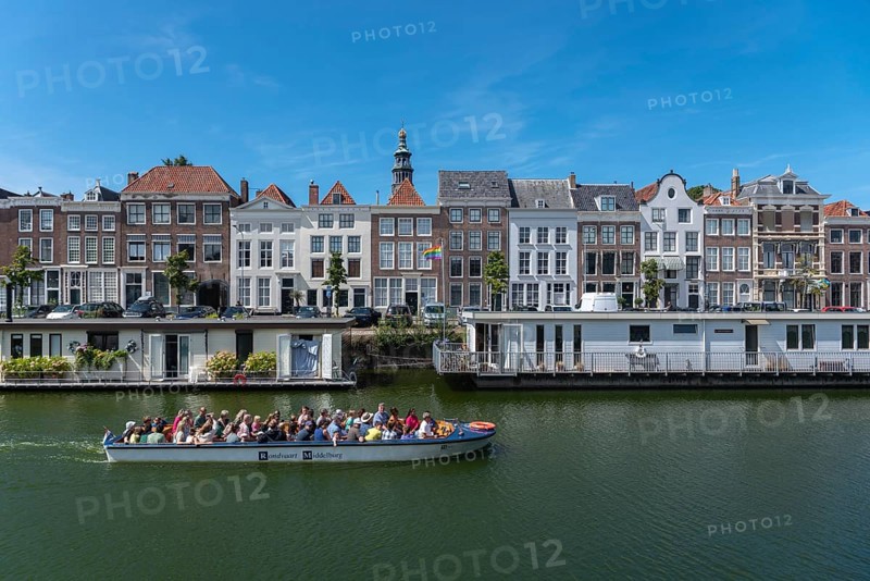 Tour boat in front of historic house facades and houseboats at Londensekaai