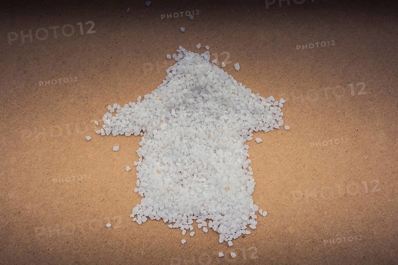 Arrow formed by some white sand on brown paper