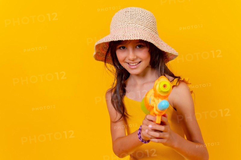 Portrait of a girl playing with a water gun on summer vacation