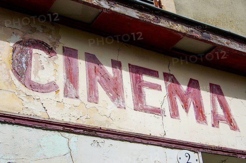 Faded old French lettering Cinema on a house facade in France