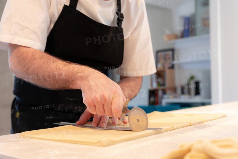 Detail of the hands of a man baking croissants