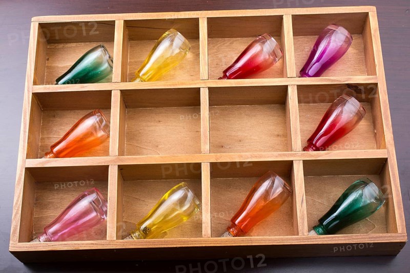 Colorful small bottles in a wooden box in the view