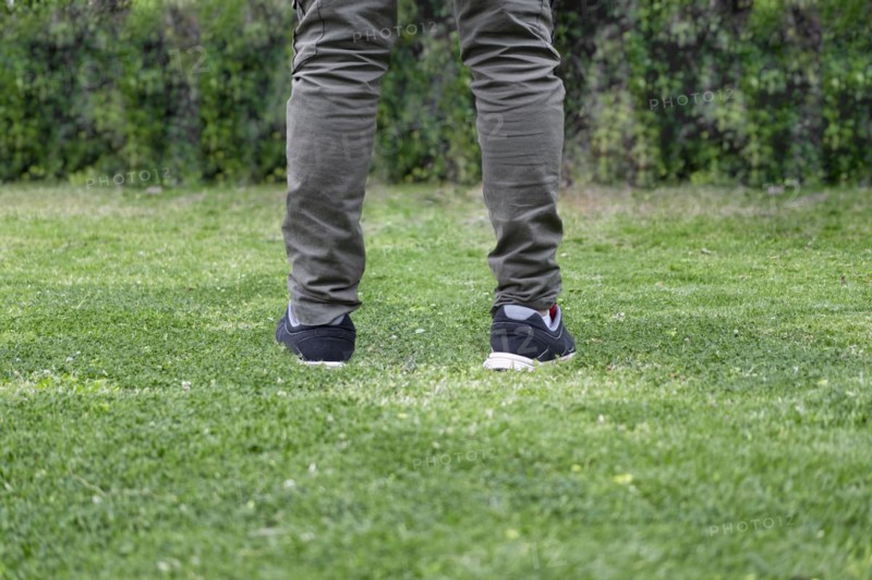 Man legs walking over green grass
