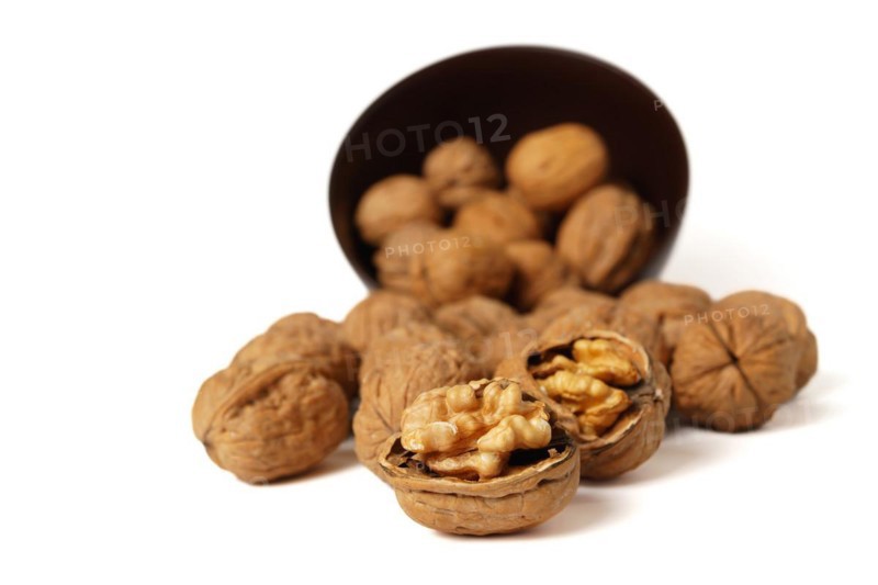 Walnuts in a brown bowl isolated on a white background