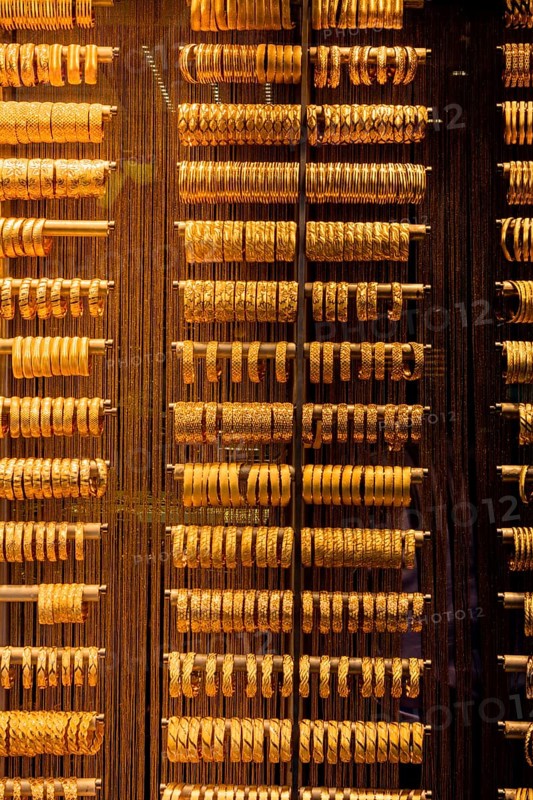 Shop display of dozens of golden bracelets and bangles