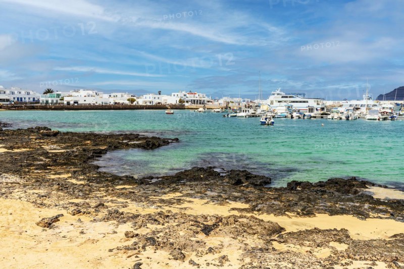 Beach and port with boats and ferries in Caleta del Sebo