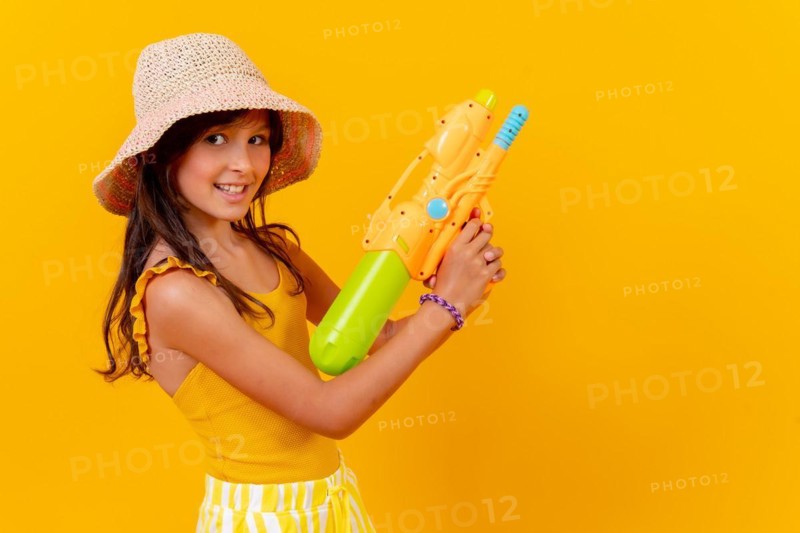 Portrait of a girl with a water pistol on summer vacation