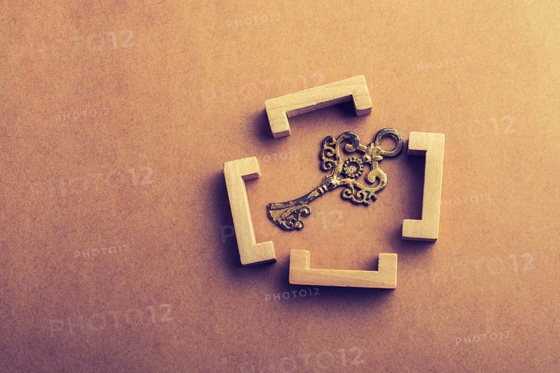 Retro style key in wooden brackets on wooden background