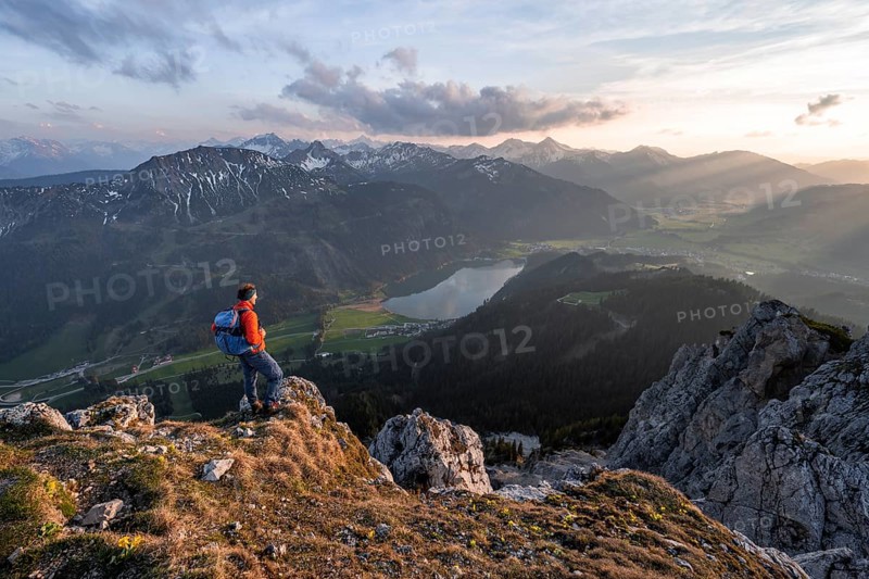 Hiker at the summit of Schartschrofen at sunset
