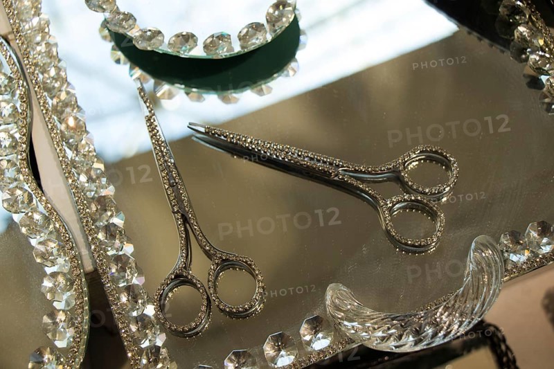 Metal scissors with diamonds on it on a mirror