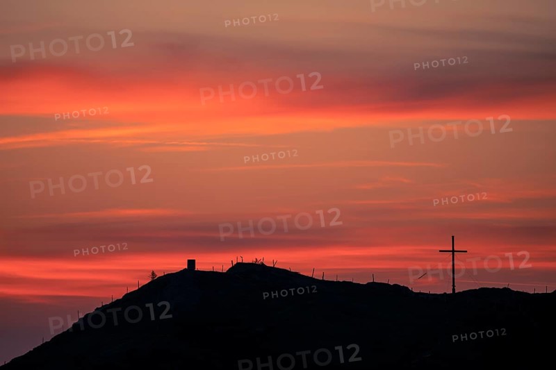 Mountain ridge with summit cross at sunrise