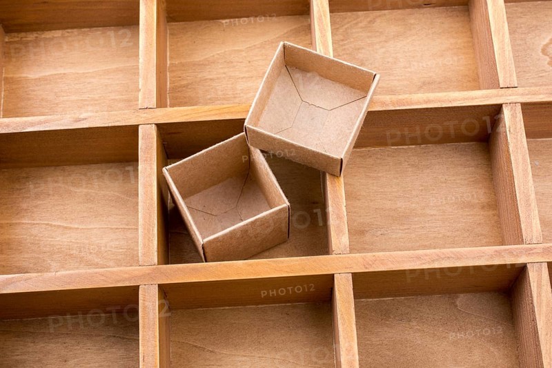 Open cardboard box inside a wooden box with compartments