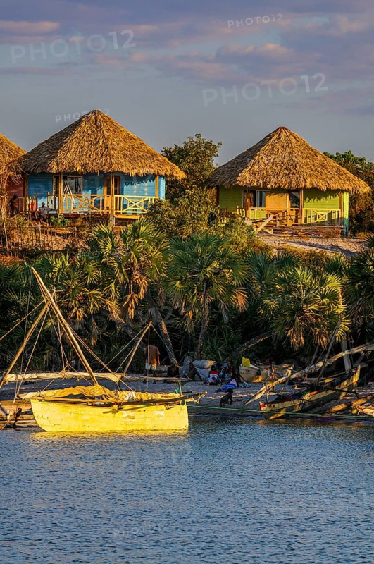 Beach bungalows above anchored sailing boats