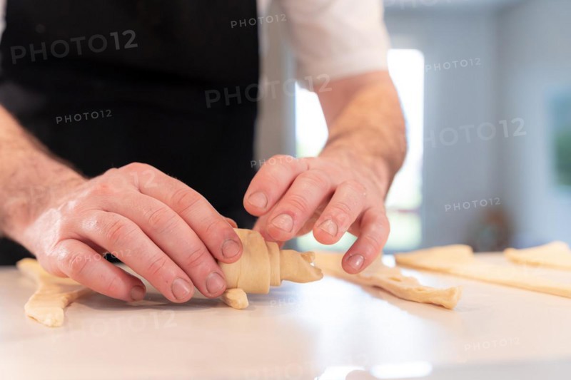 Hands of a man baking croissants
