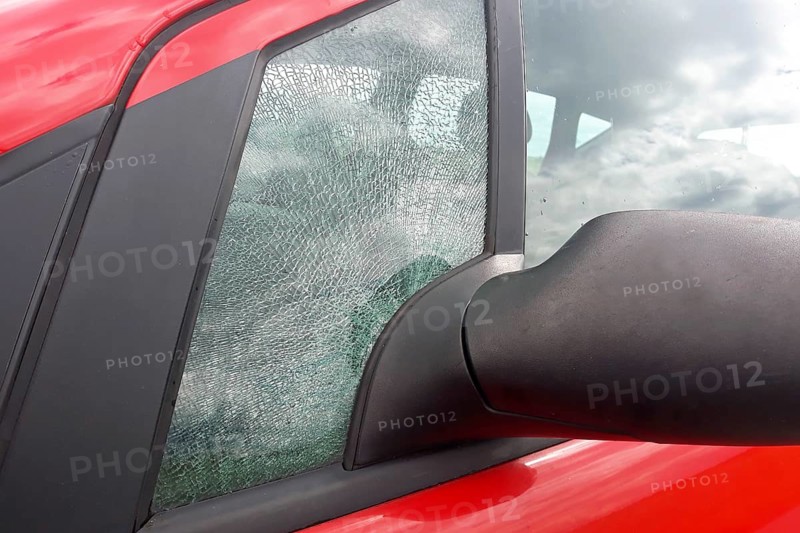 Broken front side car glass fractured into countless small pieces