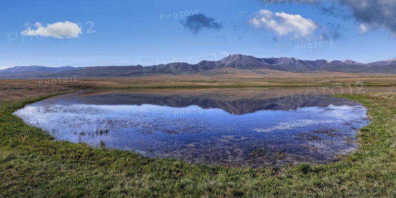 Mountains reflecting in a lake along the At-Bashy Range