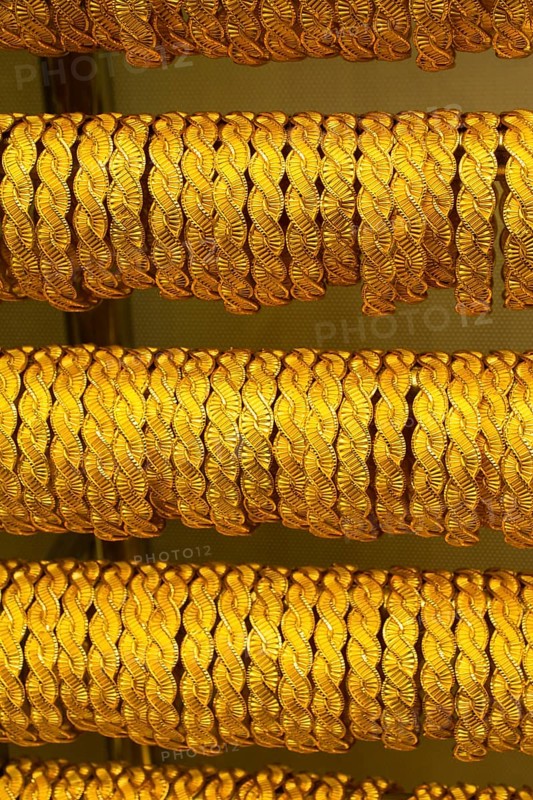 Shop display of dozens of golden bracelets and bangles
