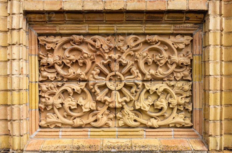 Historic architectural exterior detail with tendril ornamentation made of brick material
