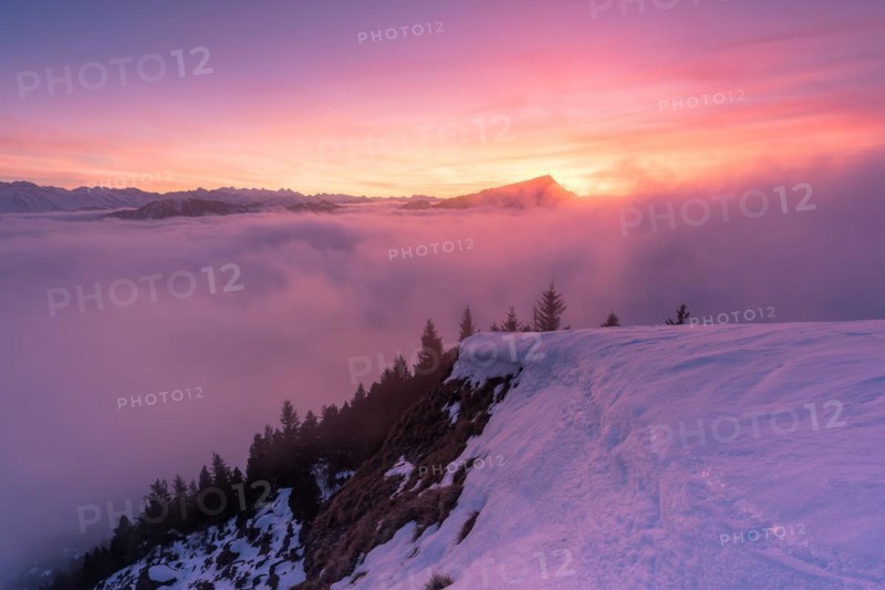 Winter landscape on the Gnipen and above the sea of fog with view towards Rigi with sunset behind