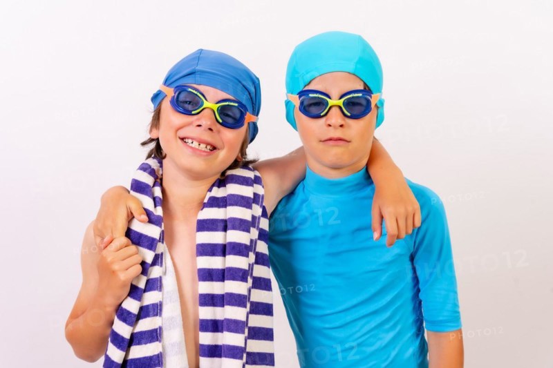 Siblings dressed and hugging in their swimsuits for swimming lessons in the pool. White background