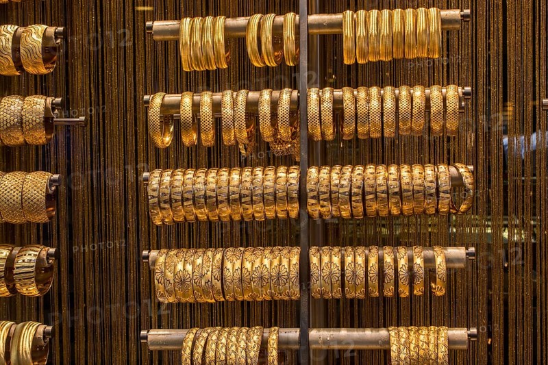 Shop display of dozens of golden bracelets and bangles