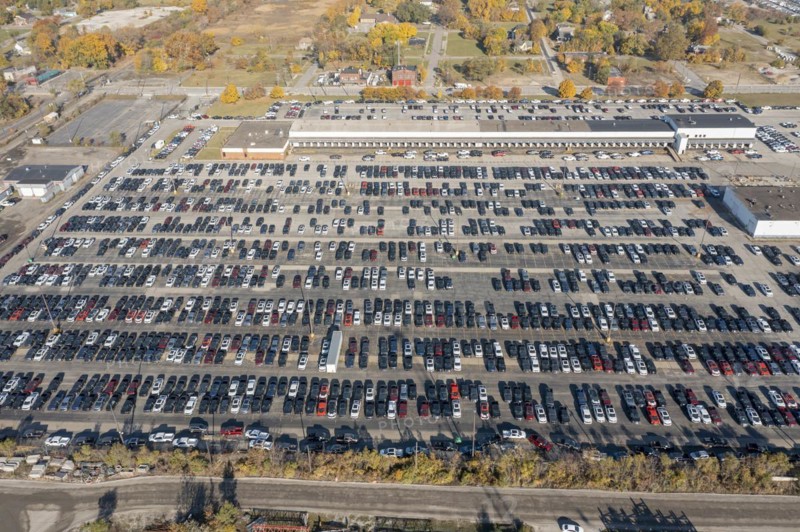 Ford pickup trucks are parked in a vacant warehouse parking lot