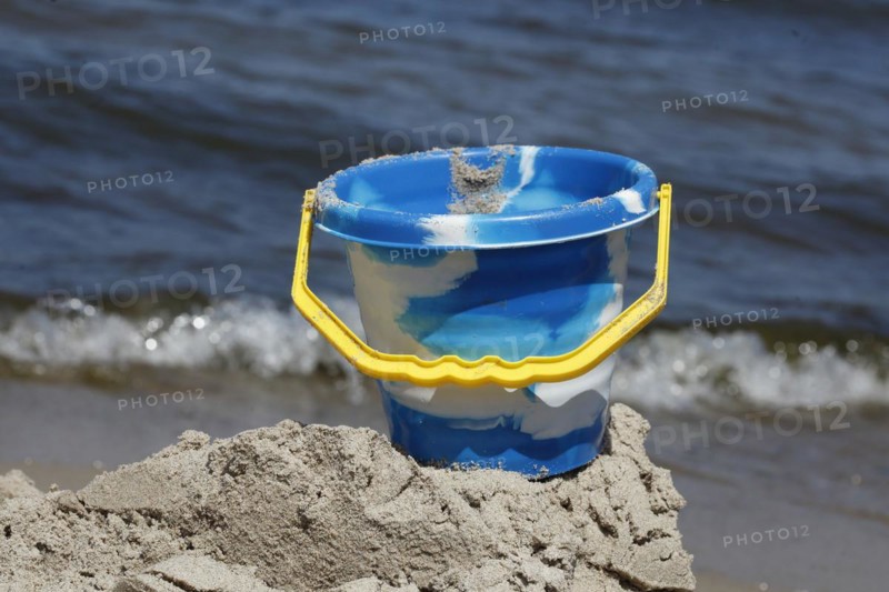 Toy and beach castle on a sandy beach by the sea