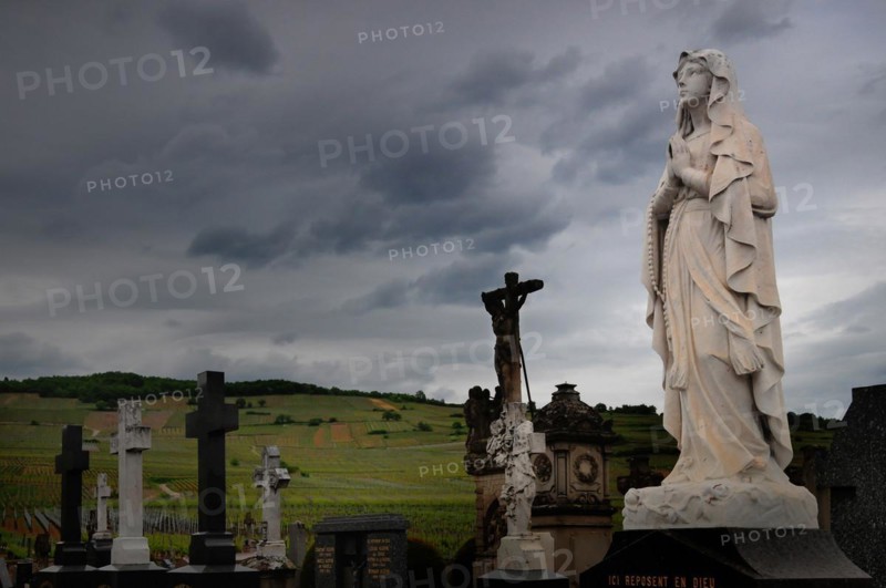 Praying statue of the Virgin Mary in a cemetery