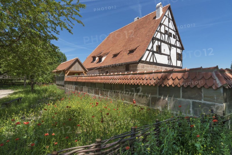 Reconstruction of a medieval bathhouse enclosed by a wall with plain tiles