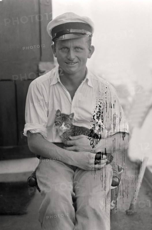 Sailor with cat in his arms on board a cargo ship