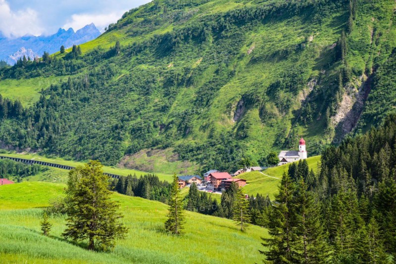 View of Damuels and the village church of Sankt Nikolaus in the Bregenzerwald in the background the Rote Wand