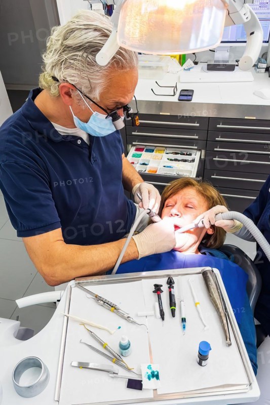 Dentist does dental prophylaxis performs dental treatment caries treatment